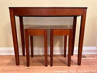 Full view of the wood console table with its two small square accent tables underneath, showing size and style