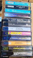 Stack of 11 vintage cassette tapes showing titles and labels, mainly from LaserLight and Capitol brands.