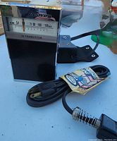 Lloyds 14 transistor AM radio with black leather case and appliance cord on a white surface.