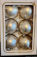 Photo of boxed set showing six silver Christmas ball ornaments with snowflake decoration