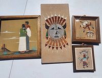 Photo showing all four framed Native American sand art pieces arranged on the floor, various sizes and designs