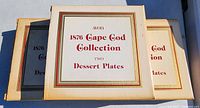 Three Avon 1876 Cape Cod Collection boxes, each containing two dessert plates, showing box design and labeling.