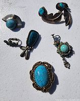 Overview of the lot showing various turquoise jewelry pieces on white background