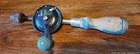 Full view of vintage Hadson hand crank drill showing wooden handle, metal crank, and chuck.