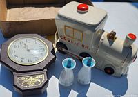 Full lot photo showing vintage General Electric electric clock, ceramic cookie jar shaped like train, and glass salt and pepper shakers.