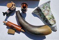 Photo showing ceramic floral wall planter vase, wooden rolling pin, metal vase and horn vessel