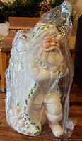Front view of vintage Lenox Santa Claus cookie jar in plastic wrapping showing detailed face and holly trim on coat and sack.
