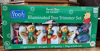 Front of box showing the Pooh Illuminated Tree Trimmer Set by Santa's Best EZ Light with 5 light covers including Piglet, Pooh (two), Tigger, and Eeyore.