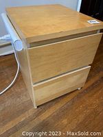 Wooden 2 drawer side table with light wood finish, top view and side showing Noma power bar attached, white power cord visible.