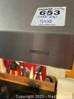 Close-up photo showing the Broan brand logo on stainless steel surface of the oven fan light hood.