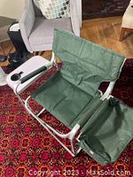 Green director style camping chair showing aluminum frame, fabric seat, side cooler on one side and side table with cup holder on the other armrest