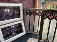 Four antique stained and leaded glass windows including two with purple stained and frosted patterned glass and two with leaded glass and frosted patterned centers, pictured together.