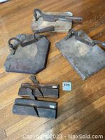 Top photo showing 3 cutters with cast iron bases and wooden handles and 2 wooden planers laid out on the wooden floor.