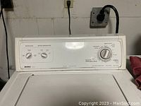 Front and control panel view of Kenmore 70 Series washing machine in white, showing knobs and settings.