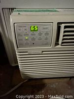 Close-up of the digital control panel on the Kenmore window air conditioner showing LED temperature display set to 65 degrees and control buttons.