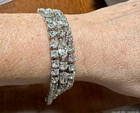 Bracelet worn on wrist showing three rows of clear rhinestones and silver-tone base.