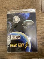 Overall view of the sealed set packaging showing the 25 cent coin above and the stamp set below with Star Trek imagery on the cover.