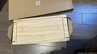 Top view of the unboxed wooden tray showing handles and wood grain.
