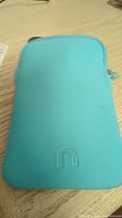 Blue protective sleeve case for Kindle on wooden surface