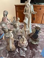 Group shot of eight Lladro figurines on marble table