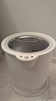 Full view of white plastic towel warmer with transparent lid and handle