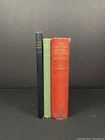 Three vintage hardcover fishing books standing upright against a black background. Spine names and colors visible showing title and authorship.