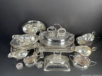 Grouped silver plated items including chafing dish with stand, gravy boats, relish dish, oval server, butter dish, sugar bowl, salt cellar