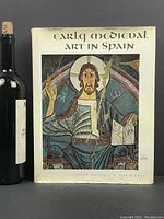 Front cover of vintage art book 'Early Medieval Art in Spain' with dust jacket depicting medieval religious art.