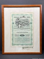 Framed bond certificate showing full paper within wooden frame, with cream matting.