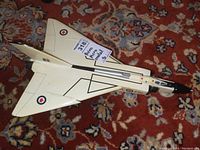 Top view of the Avro Arrow desk model on carpeted floor showing delta wing and Canadian Air Force roundels.