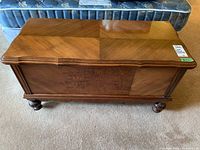 Front view of cedar chest showing parquet veneer top and bun feet
