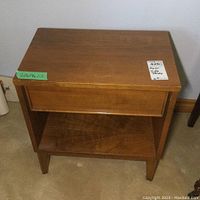 Front view of a rectangular wooden side table with medium brown finish, showing dimensions sticker 20x14x22 and auction lot sticker on top right corner.