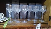 Seven Wynnewood glasses displayed side by side with three original Waterford boxes behind