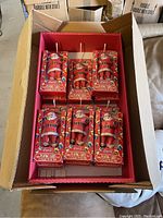 Photo of the full case containing 12 Coca-Cola Santa Claus playing card tins in retail packaging.