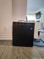 Front view of black Danby bar fridge with brand logo visible on top center of the door.