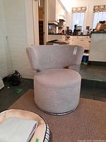 Front view of the beige bun swivel chair showing full design in a kitchen setting.
