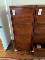 Front view of the four drawer wood file cabinet showing vertical drawers and key lock on top drawer.