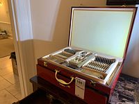 Open wooden case showing all flatware pieces in foam insert