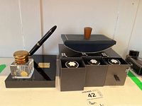 Wide view of lot showing pen on stand, inkwell, blotter, three boxed ink bottles and additional ink bottle