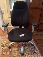 Front view of the black office chair showing padded seat and backrest, armrests, and wheelbase.
