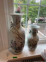 Both vases side by side on a windowsill showing overall appearance and relative size.
