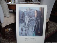 Framed print showing young lady and cow in snow, angled view