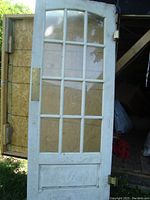 Full view of the white wooden interior swing door with 15 glass panes and a lower solid panel, showing the door's overall condition and size.
