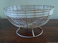 Metal wireframe fruit bowl with an oval shape and pedestal base, distressed silver finish, photographed against a plain background.
