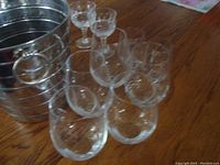 Multiple stemmed drinking glasses together with metal ice bucket