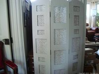 Full view of the three-panel room divider showing painted frame and fabric-covered collage sections.