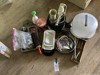 Lot of assorted bakeware items including mixer, graters, rolling pin, bowls, containers, and other kitchen tools on floor.