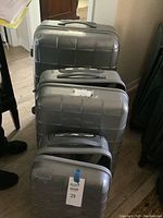 Set of three Antler hard shell suitcases stacked together, showing their exterior with visible scratches and scuff marks.