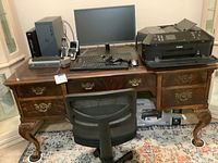 Wide view of the wooden desk with desktop computer setup, Canon printer on the right, and revolving office chair in front.