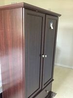 Full side and front view of the wooden wardrobe showing two doors and bottom drawer.